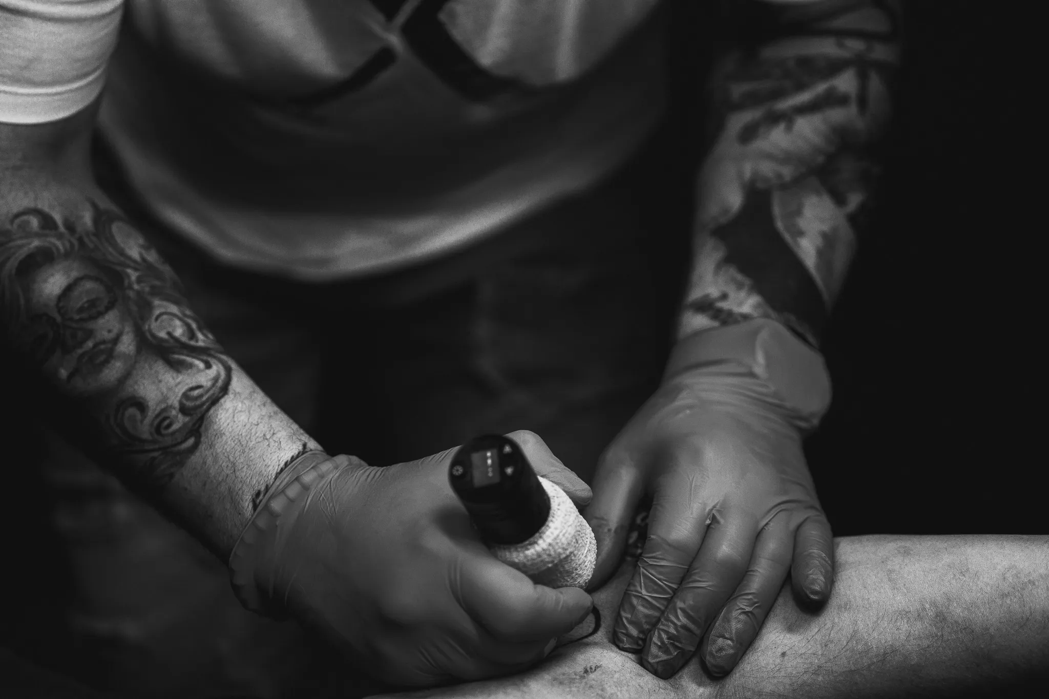 Black and white detail from a tattoo artist at work