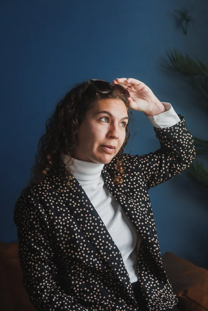 Editorial portrait against a deep blue wall