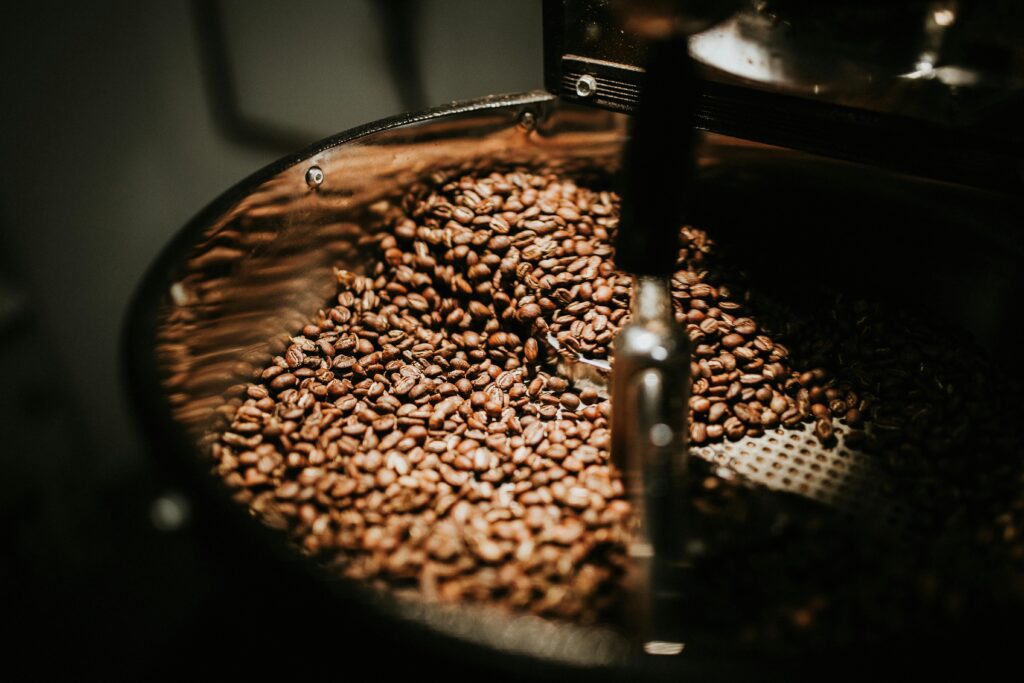 Freshly roasted coffee beans swirling inside a commercial coffee roasting drum